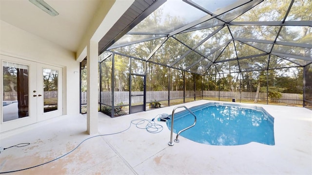 view of swimming pool featuring glass enclosure, a patio area, and french doors