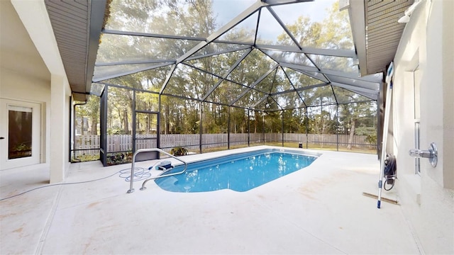 view of pool featuring glass enclosure and a patio