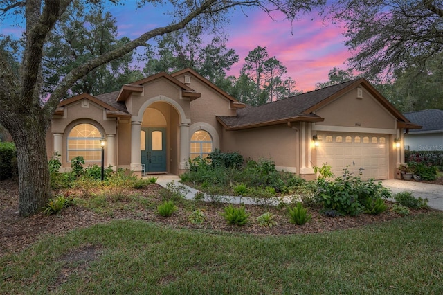 view of front of home featuring a garage and a yard