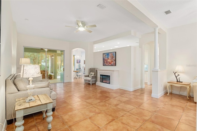 tiled living room with decorative columns and ceiling fan