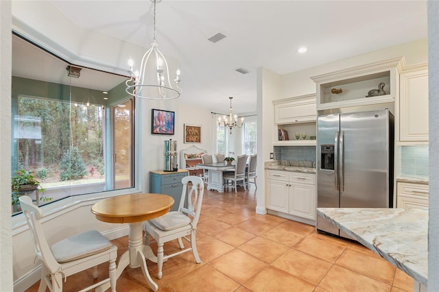 tiled dining room featuring a chandelier