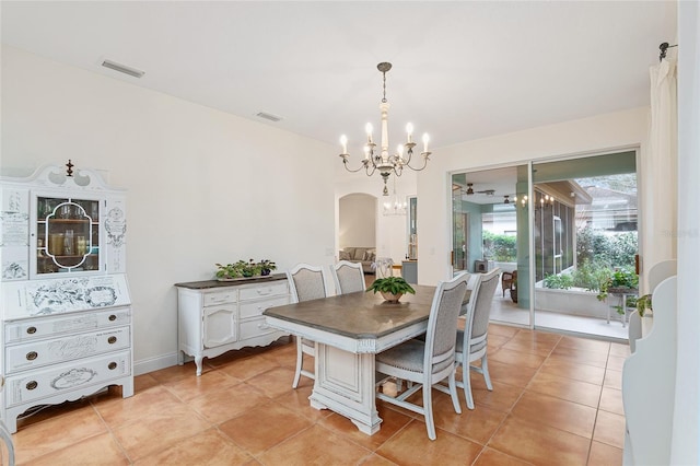 tiled dining space featuring an inviting chandelier