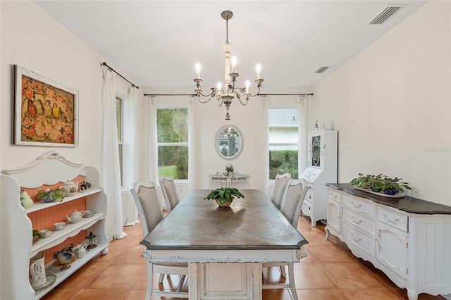 dining area with light tile patterned flooring, a healthy amount of sunlight, and a chandelier