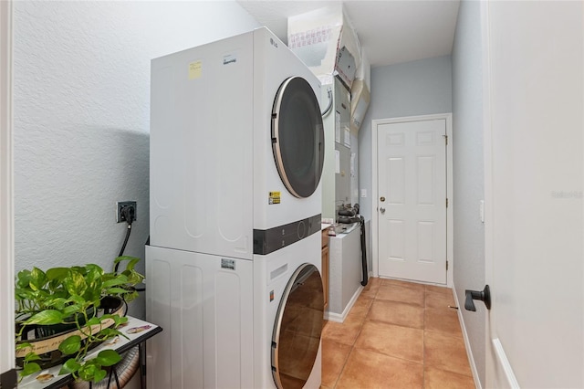 laundry room with light tile patterned floors and stacked washer and dryer