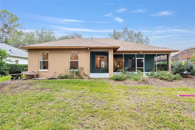 rear view of house featuring a yard and a sunroom