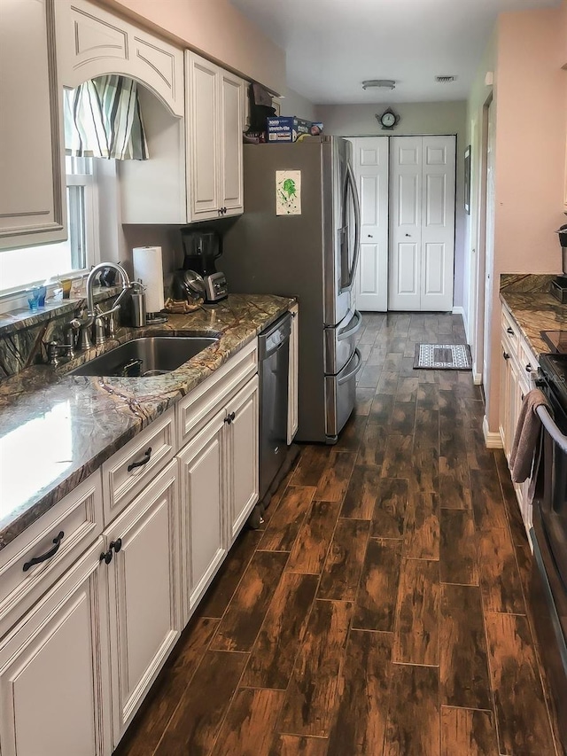 kitchen featuring black stove, stone counters, dark wood-style flooring, stainless steel dishwasher, and a sink