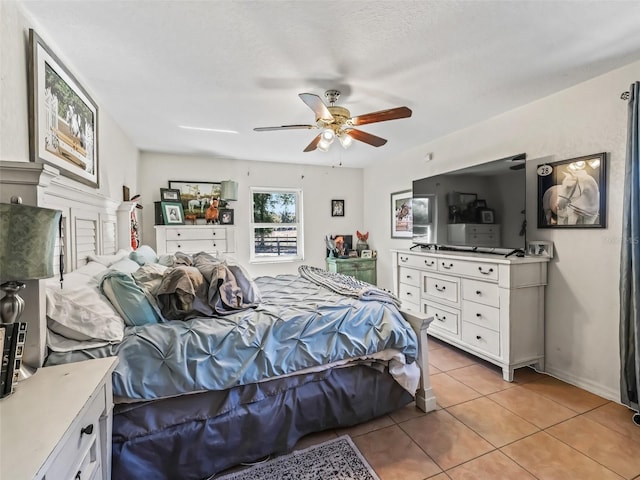 bedroom featuring light tile patterned floors, baseboards, and ceiling fan