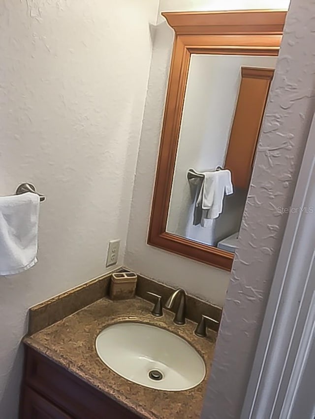 bathroom with vanity and a textured wall