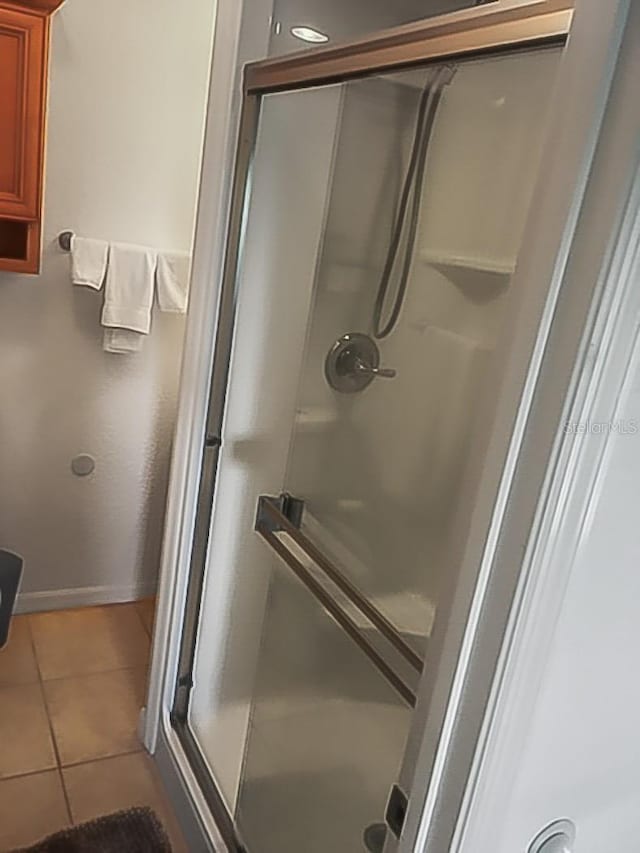 bathroom with tile patterned floors and a shower with shower door