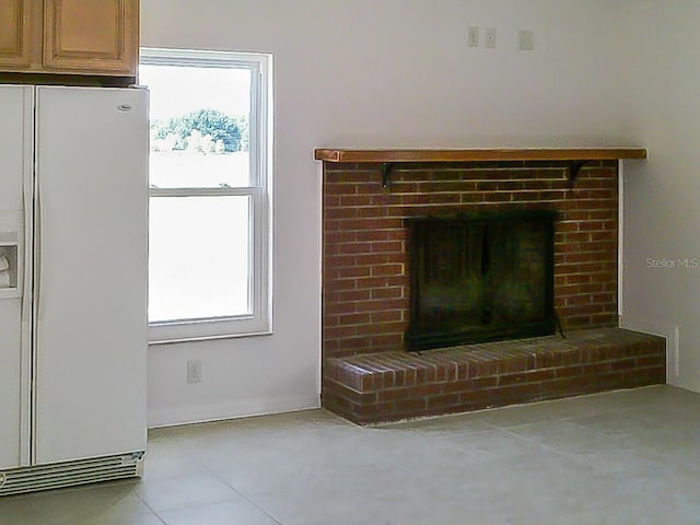 interior details featuring a fireplace and white fridge with ice dispenser