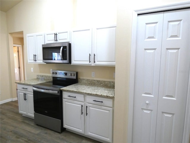 kitchen featuring stainless steel appliances, light stone counters, white cabinets, and dark hardwood / wood-style flooring