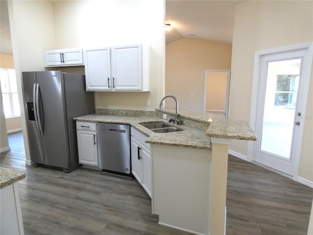 kitchen with sink, white cabinetry, stainless steel appliances, light stone countertops, and kitchen peninsula