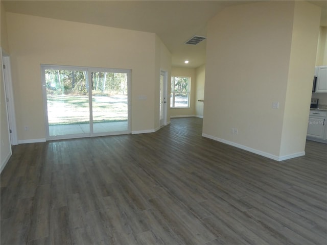 unfurnished living room with dark hardwood / wood-style flooring and vaulted ceiling