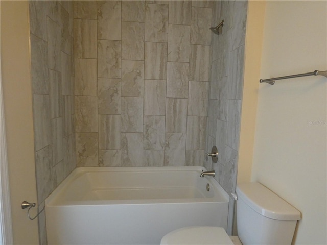 bathroom featuring tiled shower / bath and toilet