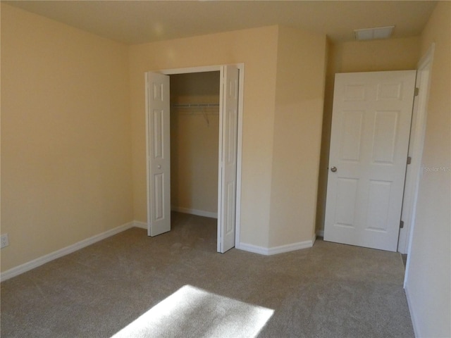 unfurnished bedroom featuring light colored carpet and a closet