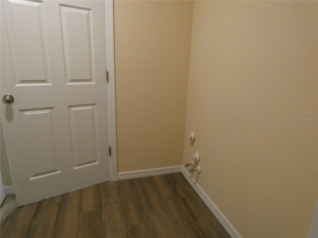 clothes washing area with dark hardwood / wood-style floors