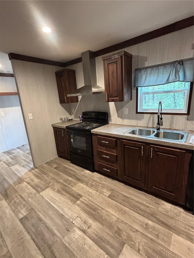 kitchen with sink, black electric range oven, wall chimney exhaust hood, and light wood-type flooring