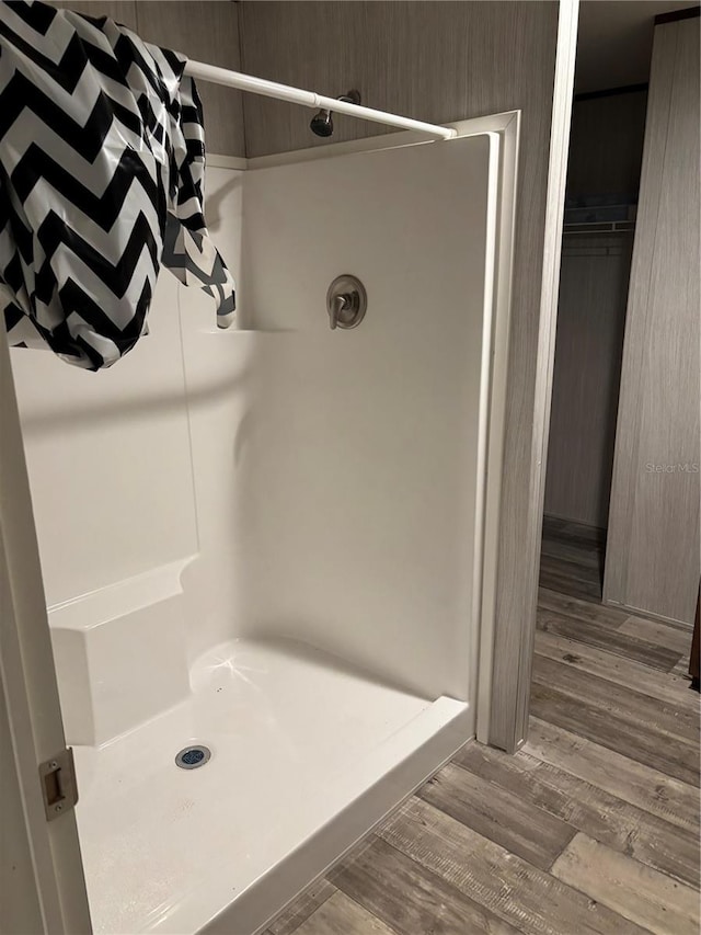 bathroom with hardwood / wood-style flooring and walk in shower