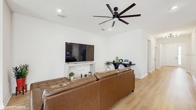 living room with ceiling fan and light hardwood / wood-style flooring