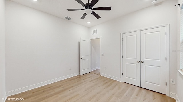 unfurnished bedroom featuring ceiling fan, a closet, and light hardwood / wood-style flooring