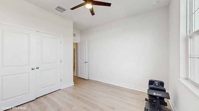 unfurnished bedroom featuring light hardwood / wood-style floors, a closet, and ceiling fan