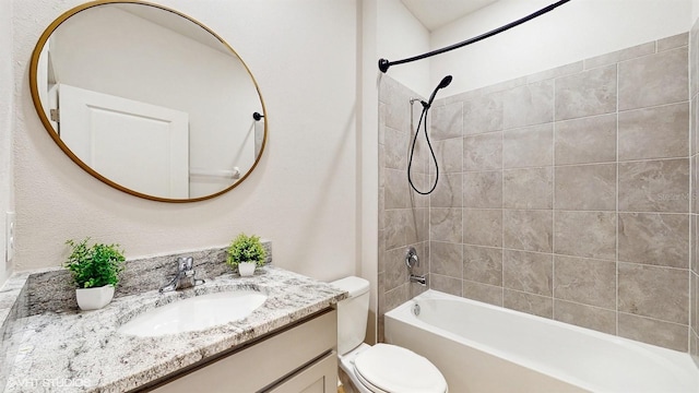 full bathroom featuring tiled shower / bath combo, vanity, and toilet