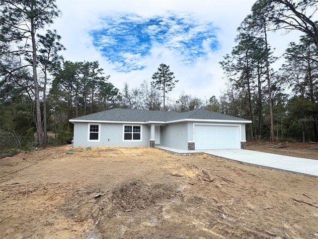 ranch-style home featuring a garage, driveway, and stucco siding