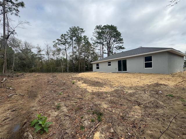 rear view of house with stucco siding