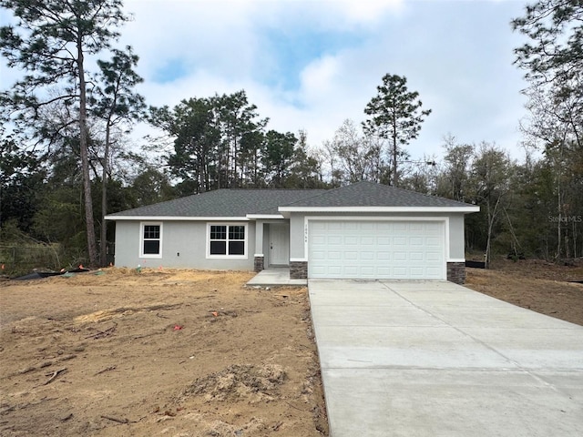 single story home with a garage, stone siding, concrete driveway, and stucco siding