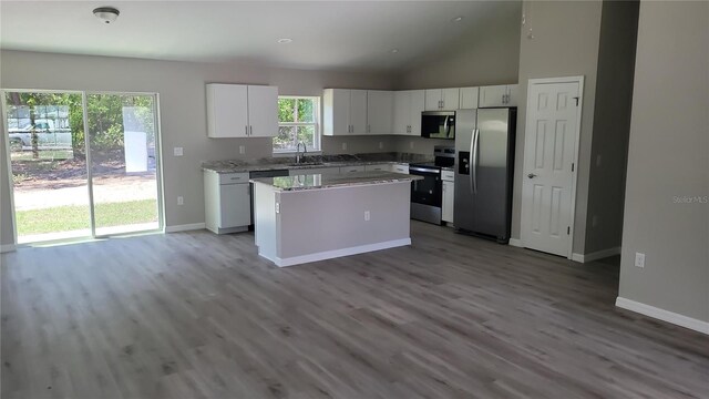 10964 N Frantz Ave, Citrus Springs, FL 34434 - kitchen with stainless steel appliances, a sink, baseboards, wood finished floors, and vaulted ceiling