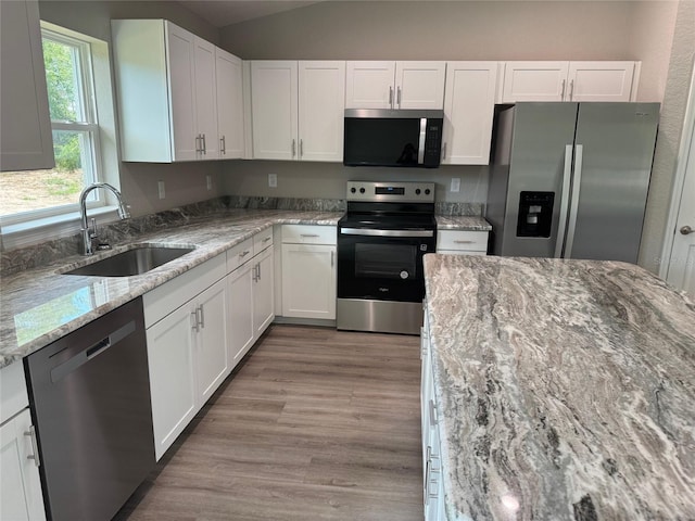 10964 N Frantz Ave, Citrus Springs, FL 34434 - kitchen featuring appliances with stainless steel finishes, a sink, white cabinets, light stone countertops, and vaulted ceiling