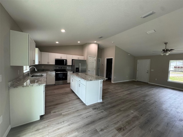 10964 N Frantz Ave, Citrus Springs, FL 34434 - kitchen featuring stainless steel appliances, a sink, a kitchen island, baseboards, and light stone counters