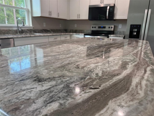 10964 N Frantz Ave, Citrus Springs, FL 34434 - kitchen featuring stainless steel appliances, light stone counters, white cabinets, and a sink