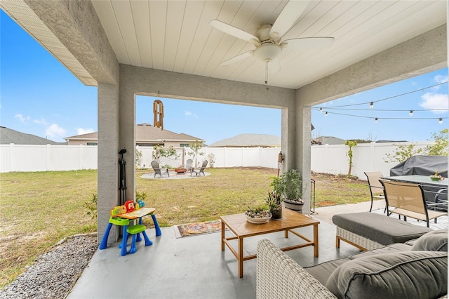 view of patio with ceiling fan, grilling area, and an outdoor living space with a fire pit