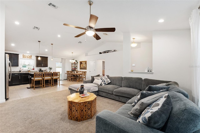 living room featuring vaulted ceiling, light tile patterned floors, and ceiling fan