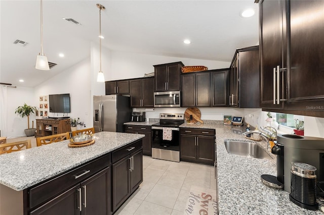 kitchen featuring hanging light fixtures, appliances with stainless steel finishes, sink, light tile patterned flooring, and lofted ceiling