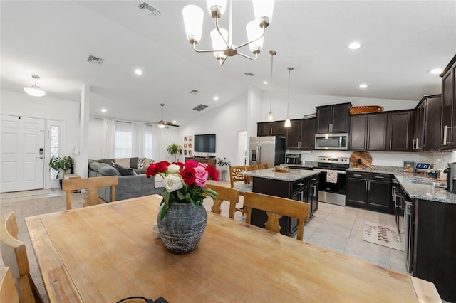 tiled dining room featuring ceiling fan with notable chandelier, sink, and high vaulted ceiling