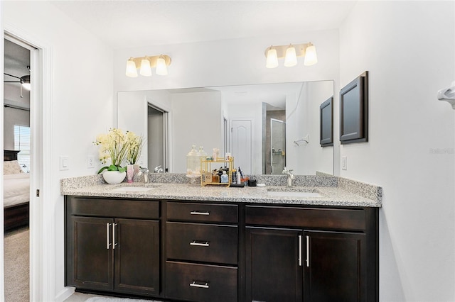 bathroom with a shower with shower door and vanity