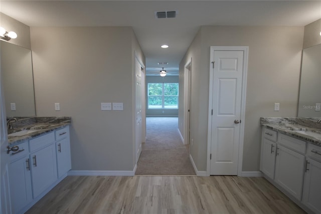 bathroom featuring vanity, ceiling fan, and wood-type flooring