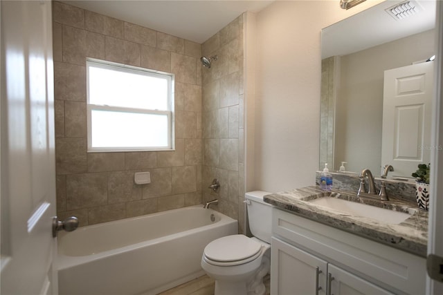 full bathroom featuring toilet, vanity, and tiled shower / bath