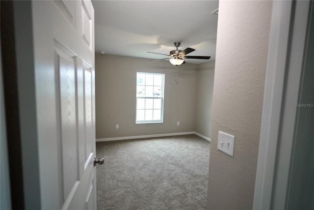 carpeted empty room featuring ceiling fan