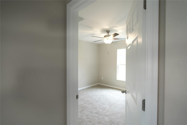 spare room featuring ceiling fan and light carpet