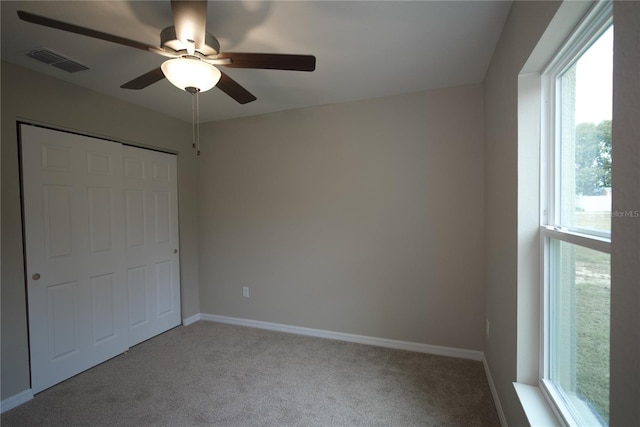 unfurnished bedroom featuring a closet, ceiling fan, and light carpet