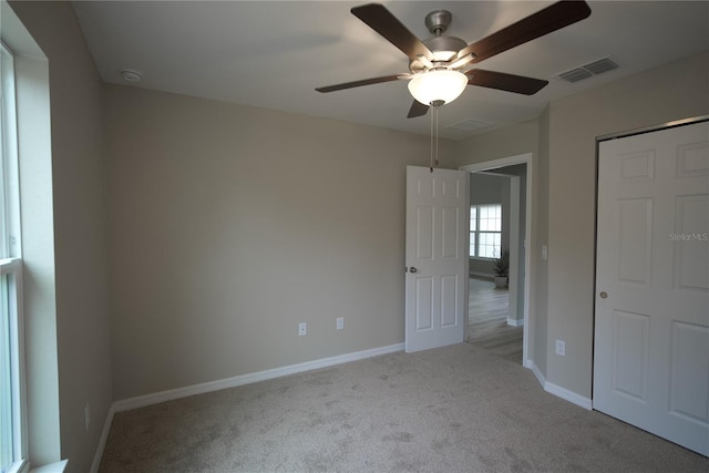 unfurnished bedroom featuring a closet, ceiling fan, and light carpet