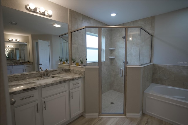 bathroom with vanity, hardwood / wood-style flooring, and shower with separate bathtub