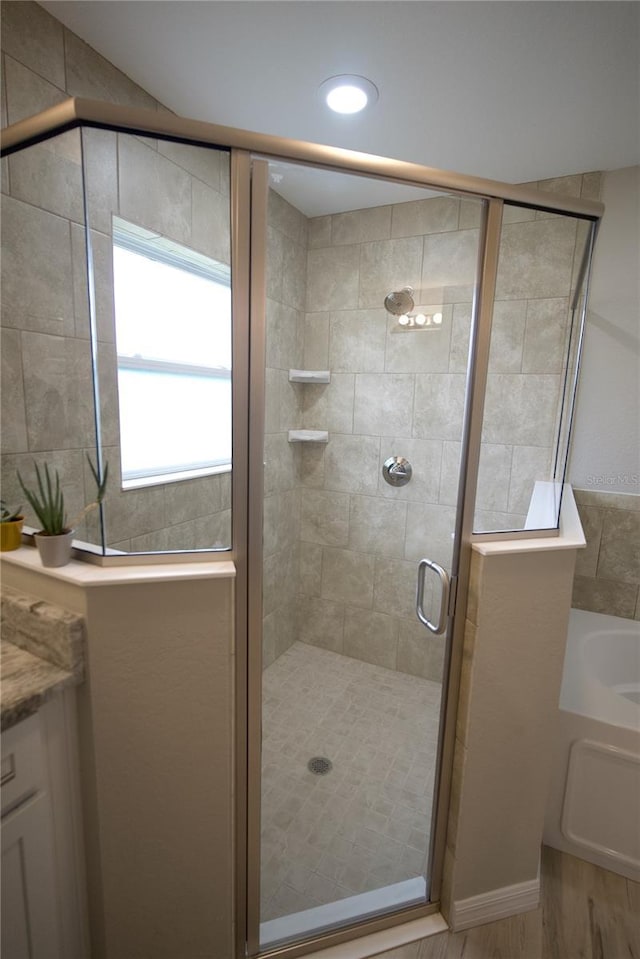 bathroom featuring vanity, a shower with shower door, and hardwood / wood-style floors