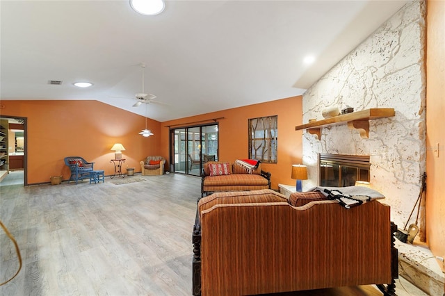 living room with hardwood / wood-style flooring, a fireplace, ceiling fan, and vaulted ceiling