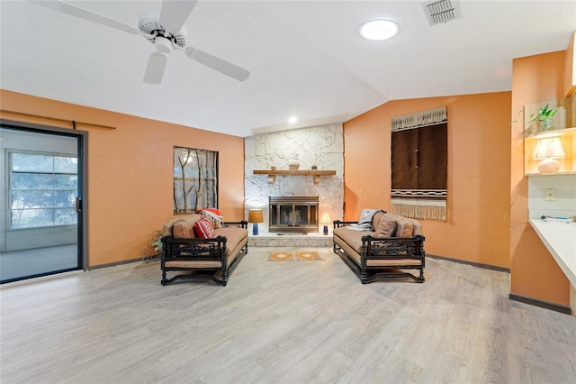 living room featuring hardwood / wood-style flooring, lofted ceiling, ceiling fan, and a fireplace