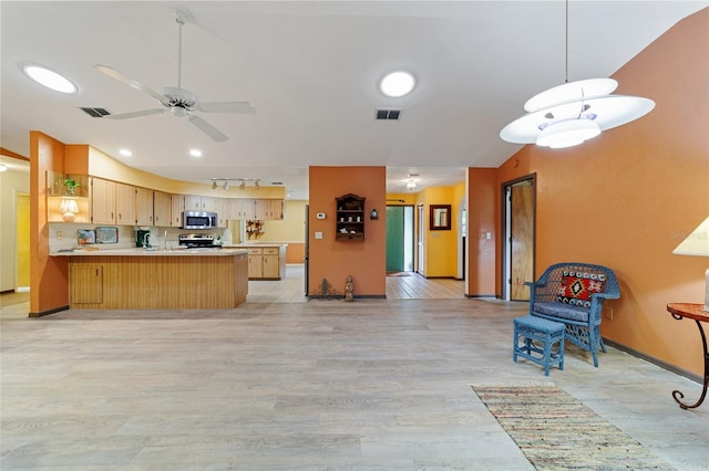 kitchen featuring light brown cabinets, stainless steel appliances, kitchen peninsula, light wood-type flooring, and ceiling fan