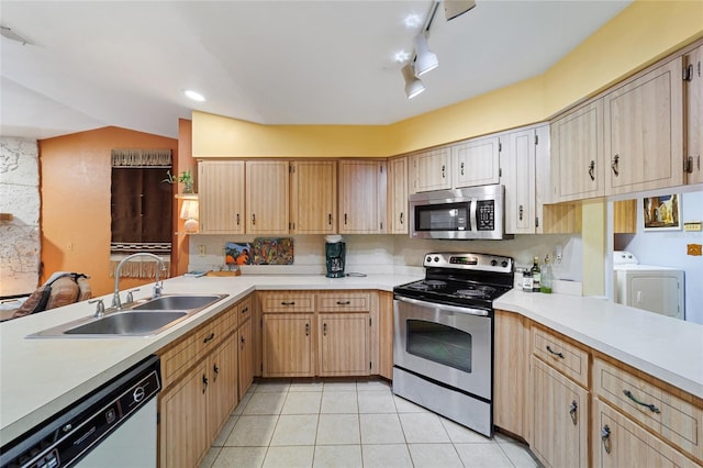 kitchen featuring appliances with stainless steel finishes, sink, track lighting, separate washer and dryer, and light tile patterned flooring